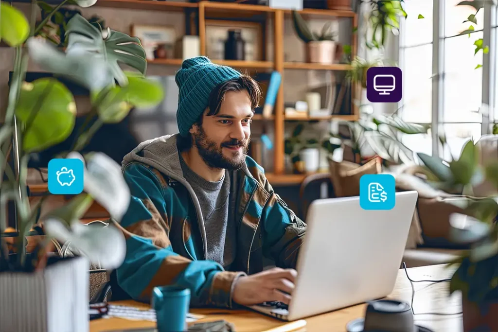 Homem usando touca, concentrado em seu laptop, lidando com finanças para freelancers.