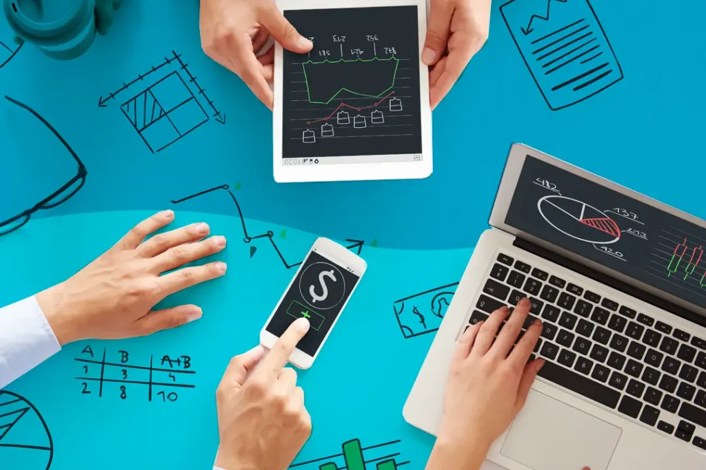 Despesas e Receitas: entenda suas diferenças e otimize seu controle financeiro 1 Profissionais de negócios utilizando laptops e tablets, analisando diagramas de despesas e receitas.
